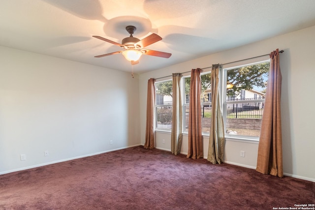 empty room with dark colored carpet and ceiling fan