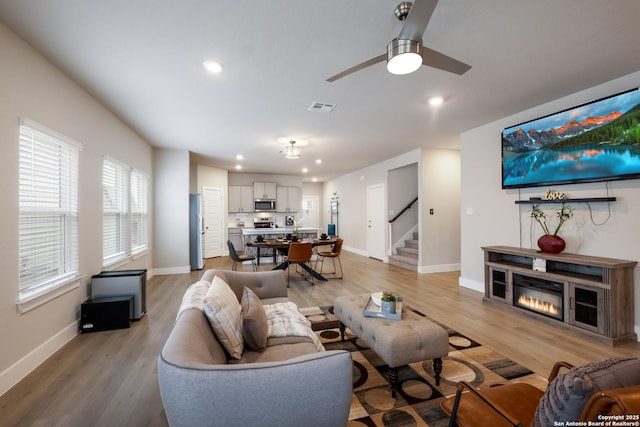 living room featuring ceiling fan and light hardwood / wood-style flooring