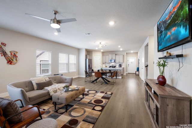 living room with ceiling fan and light wood-type flooring