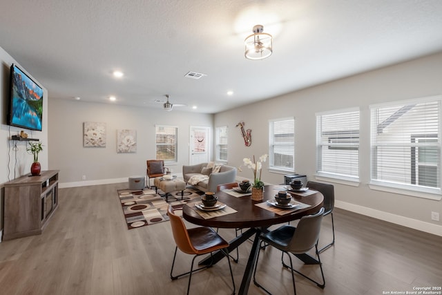 dining space featuring wood-type flooring and ceiling fan