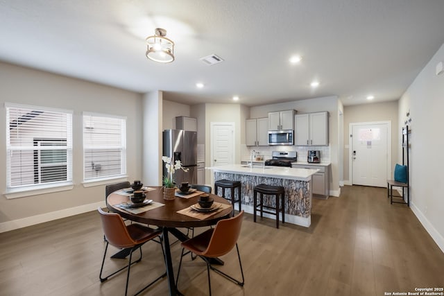 dining room with dark hardwood / wood-style flooring and sink