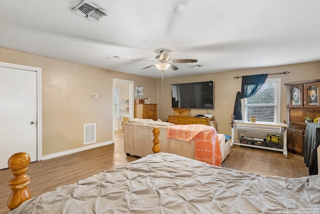 bedroom with connected bathroom, ceiling fan, and light hardwood / wood-style floors