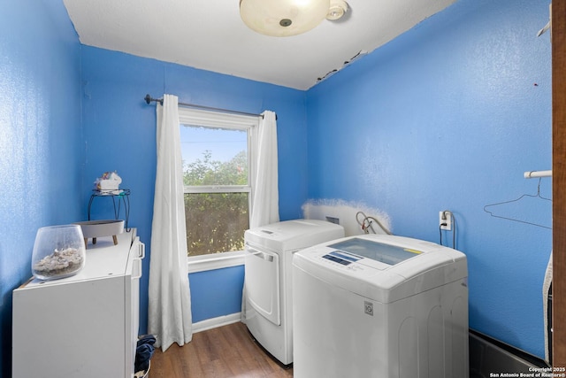 laundry room featuring separate washer and dryer and hardwood / wood-style floors