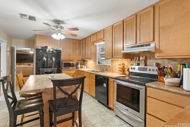 kitchen featuring tasteful backsplash, light tile patterned floors, sink, and black appliances