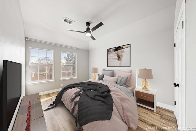 bedroom with light hardwood / wood-style floors and ceiling fan