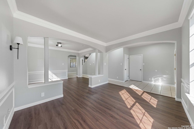 spare room with crown molding and dark wood-type flooring