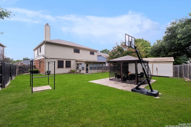 rear view of house featuring a shed, a gazebo, a lawn, and a patio area