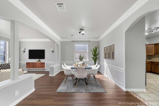 dining space featuring a healthy amount of sunlight, ornamental molding, and hardwood / wood-style floors