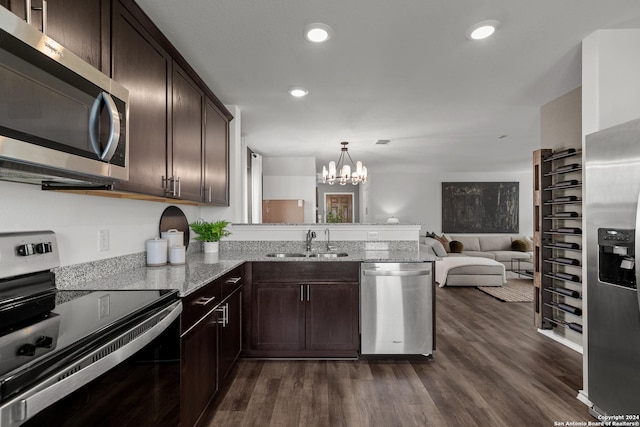 kitchen featuring stainless steel appliances, sink, dark brown cabinetry, and decorative light fixtures