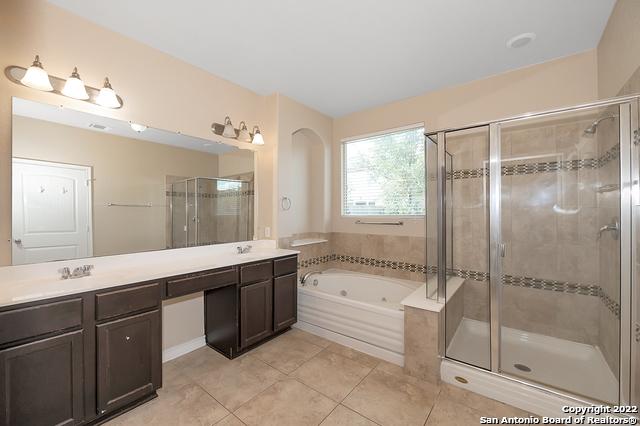 bathroom with vanity, tile patterned flooring, and plus walk in shower