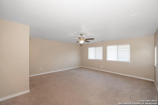 unfurnished room with ceiling fan and light carpet