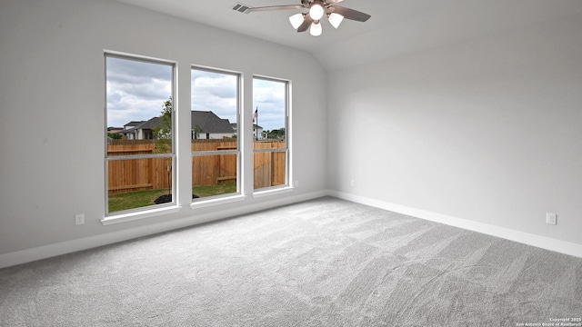 empty room with carpet floors, ceiling fan, baseboards, and lofted ceiling