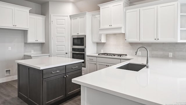 kitchen with open shelves, white cabinets, a sink, backsplash, and stainless steel appliances