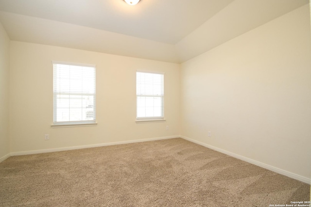 carpeted spare room with lofted ceiling and plenty of natural light