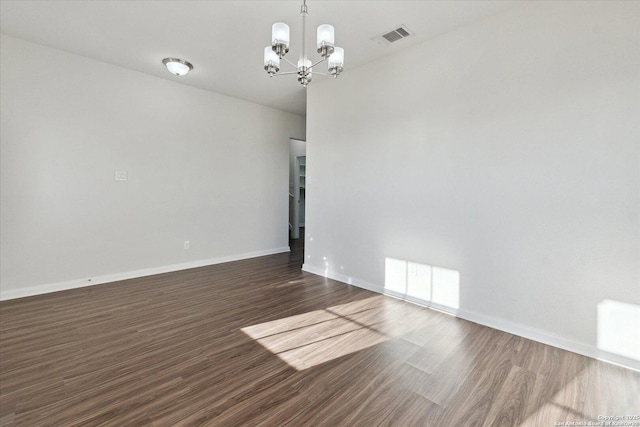 unfurnished room featuring dark hardwood / wood-style flooring and a chandelier