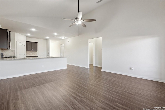 unfurnished living room with ceiling fan, dark hardwood / wood-style flooring, and high vaulted ceiling