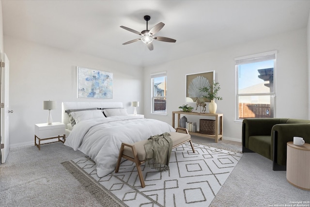 bedroom with multiple windows, light colored carpet, and ceiling fan