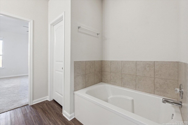 bathroom with wood-type flooring and a washtub