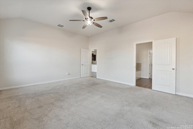 empty room featuring lofted ceiling, ceiling fan, and carpet flooring