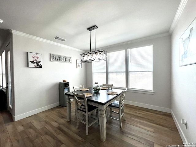 dining area featuring dark wood-type flooring and ornamental molding