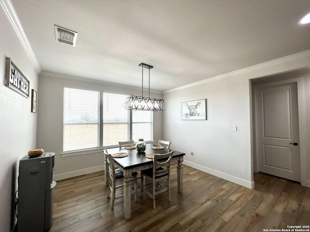 dining area featuring ornamental molding and dark hardwood / wood-style floors