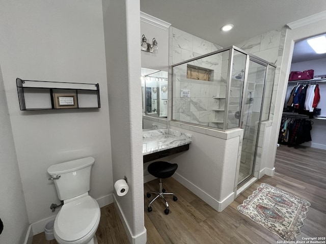 bathroom with hardwood / wood-style flooring, crown molding, and an enclosed shower