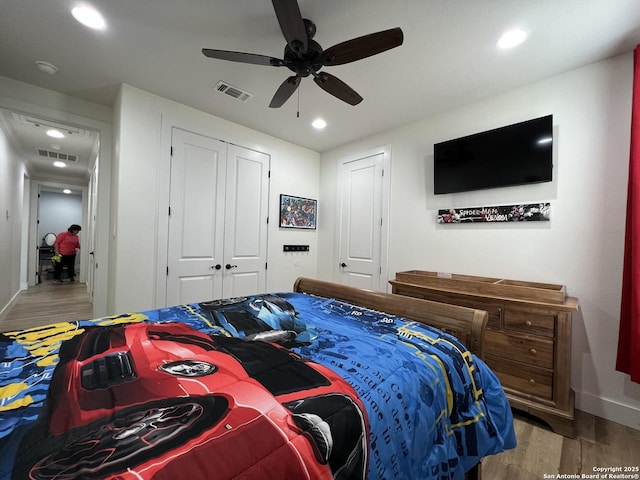 bedroom with ceiling fan, wood-type flooring, and a closet