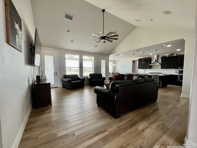 living room with wood-type flooring, ceiling fan, and vaulted ceiling