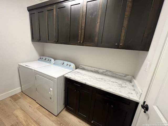 washroom with cabinets, light wood-type flooring, and washer and clothes dryer