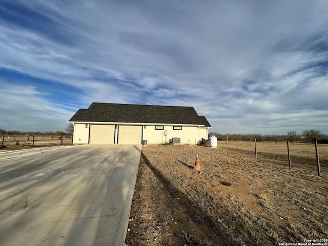 view of side of property with central air condition unit and a rural view