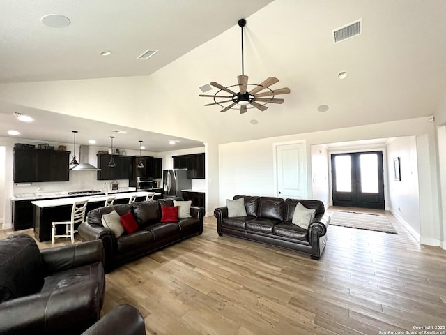 living room with ceiling fan, high vaulted ceiling, and light hardwood / wood-style floors