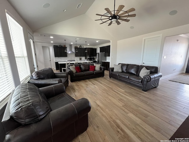 living room featuring ceiling fan, high vaulted ceiling, and light hardwood / wood-style flooring