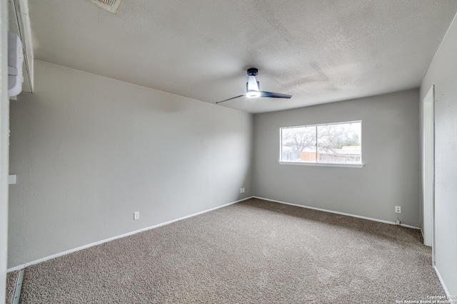 carpeted empty room featuring ceiling fan and a textured ceiling