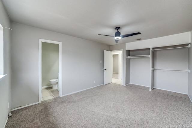 unfurnished bedroom with ensuite bath, light carpet, ceiling fan, and a closet