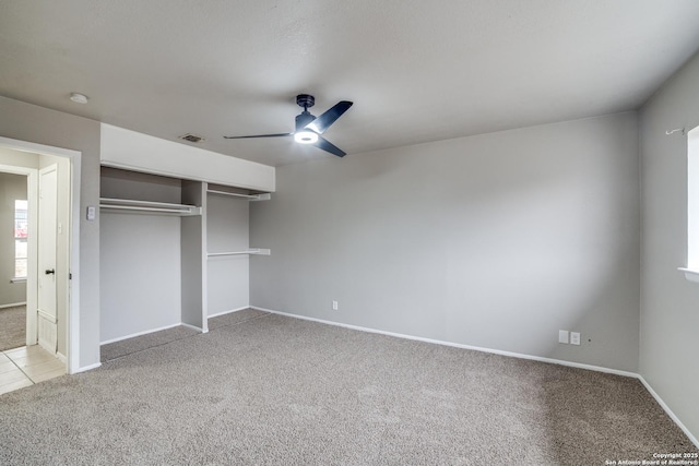 unfurnished bedroom with ceiling fan, light colored carpet, and a closet