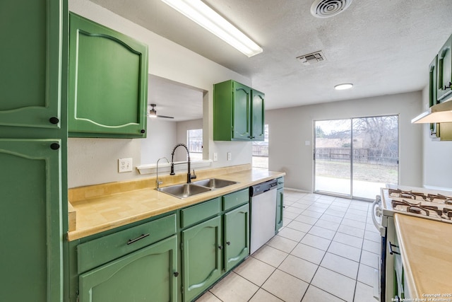 kitchen featuring appliances with stainless steel finishes, butcher block counters, sink, green cabinetry, and a textured ceiling