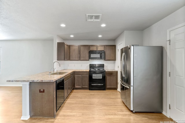 kitchen with light hardwood / wood-style floors, sink, black appliances, and kitchen peninsula