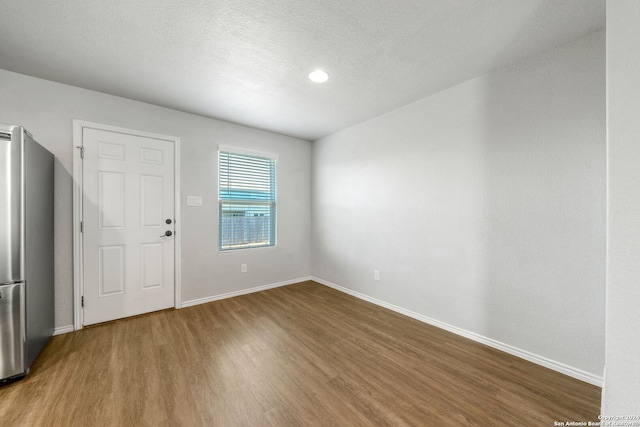 spare room with hardwood / wood-style floors and a textured ceiling