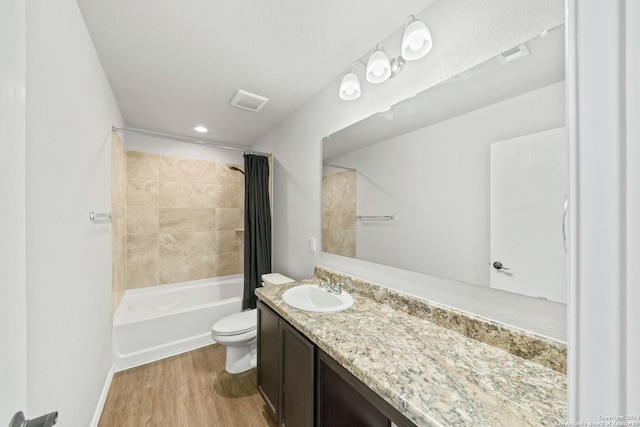 full bathroom featuring toilet, wood-type flooring, vanity, and shower / bath combo with shower curtain