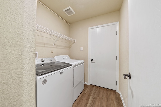 laundry area featuring hardwood / wood-style flooring and washer and clothes dryer