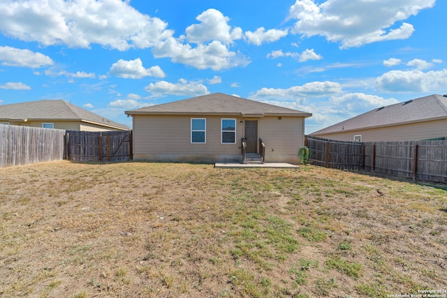 rear view of house with a yard and a patio area