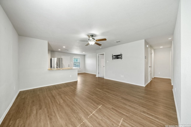 unfurnished living room featuring wood-type flooring, a textured ceiling, and ceiling fan