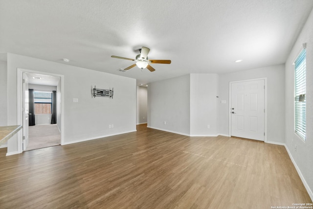 empty room with hardwood / wood-style flooring, plenty of natural light, and ceiling fan