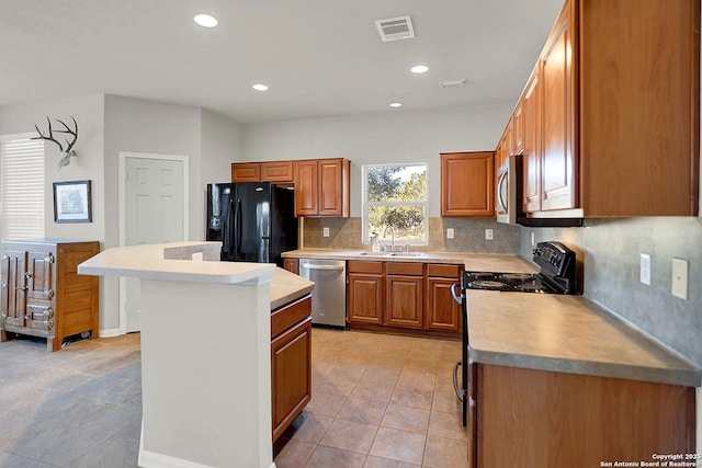 kitchen featuring light tile patterned flooring, a kitchen island, sink, decorative backsplash, and black appliances