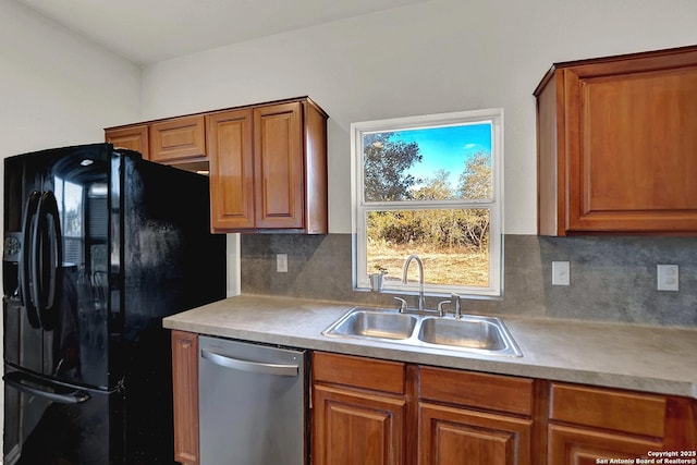 kitchen featuring black refrigerator, dishwasher, sink, and backsplash