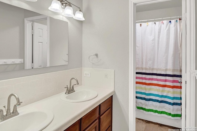 bathroom with a shower with curtain, vanity, and decorative backsplash