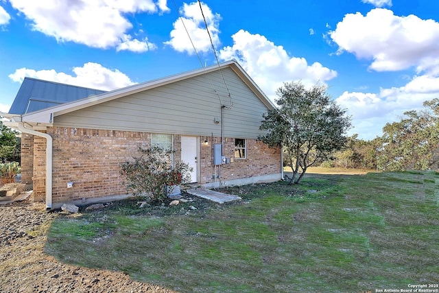 view of side of home with a yard