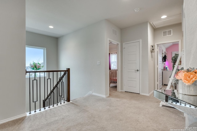 hall featuring light colored carpet