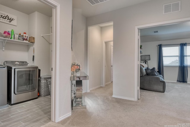 clothes washing area featuring washer and dryer and light colored carpet