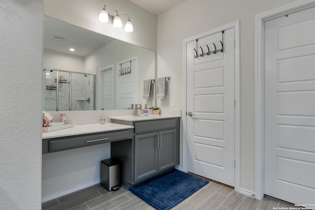 bathroom with walk in shower and vanity